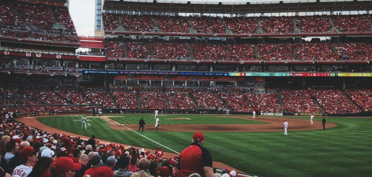 Fans fill the stands at a Cincinnati baseball game, illustrating the economic impact of local sports on the city.