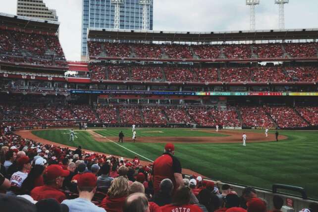 Fans fill the stands at a Cincinnati baseball game, illustrating the economic impact of local sports on the city.