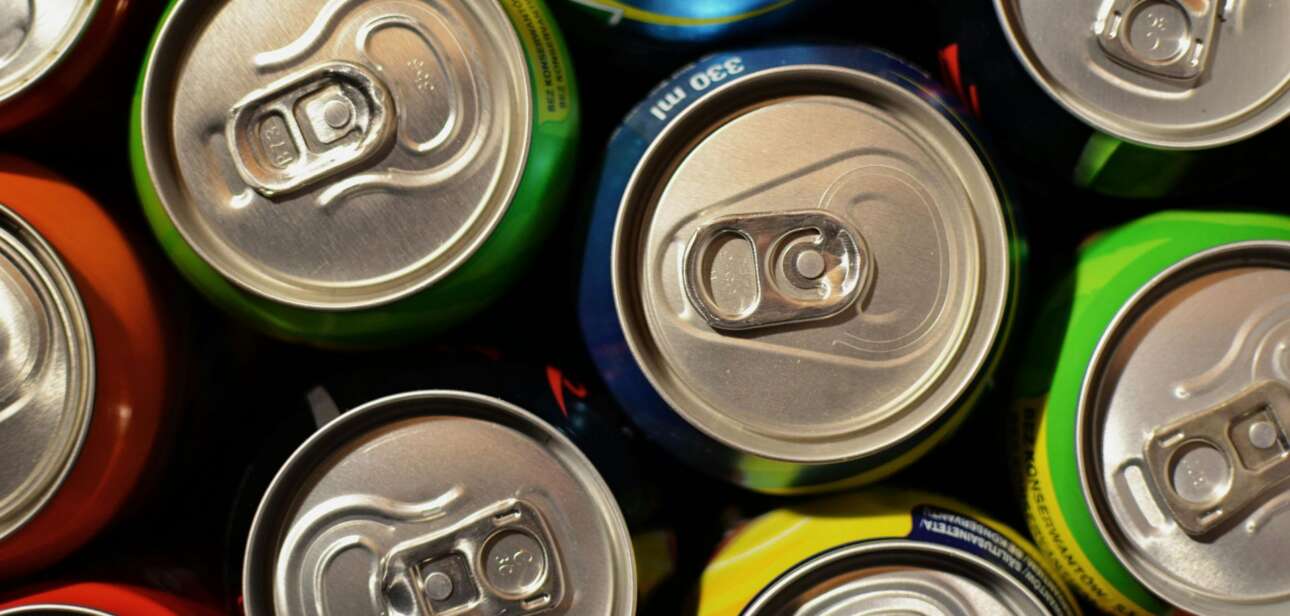 Overhead close-up of tightly packed, brightly colored aluminum beverage cans.