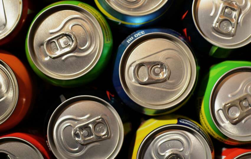 Overhead close-up of tightly packed, brightly colored aluminum beverage cans.