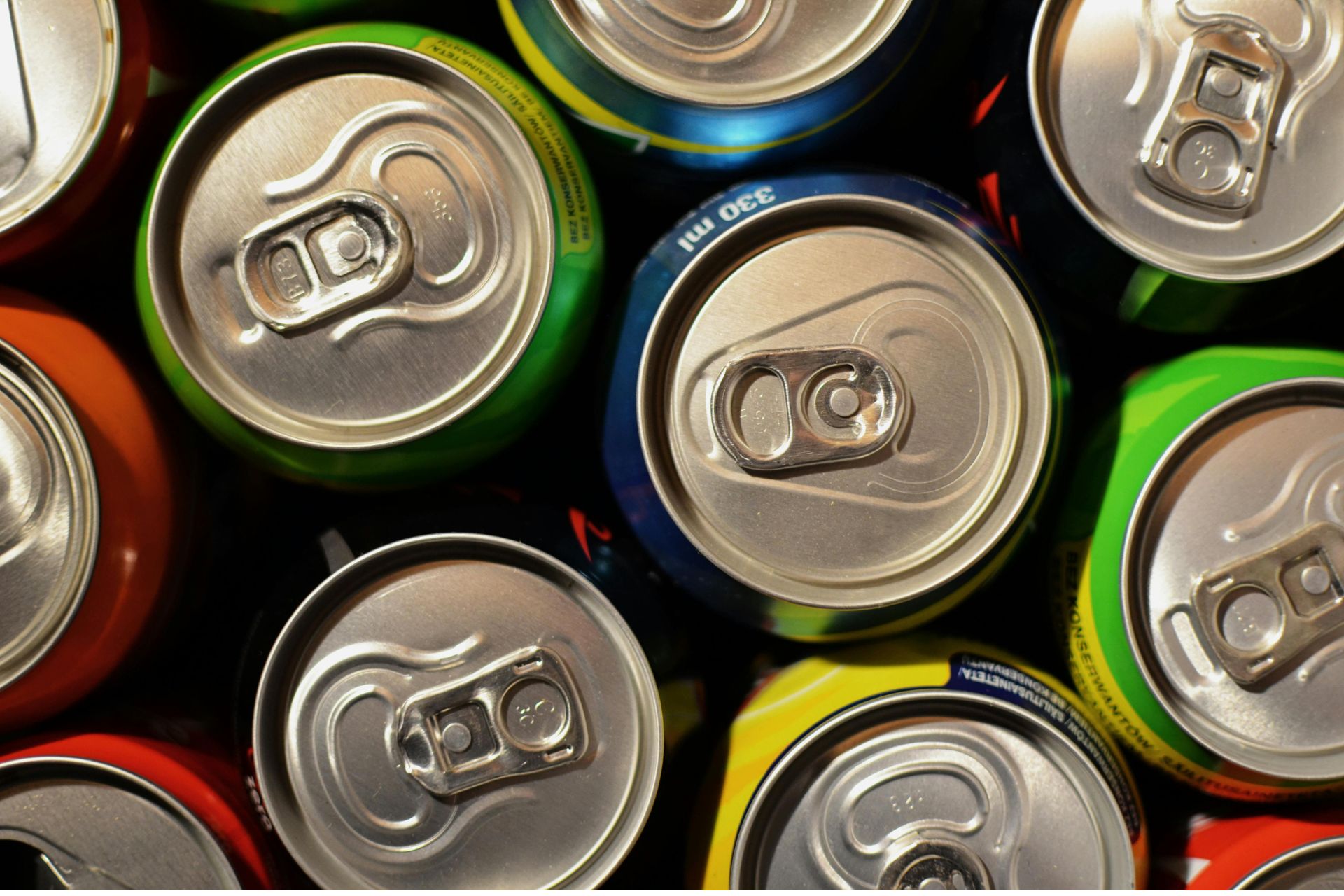 Overhead close-up of tightly packed, brightly colored aluminum beverage cans.