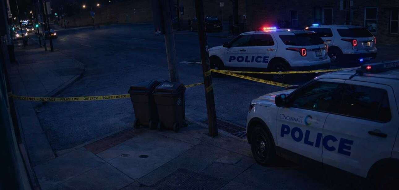 Cincinnati police vehicles block off Vine and Hubert streets in Over-the-Rhine at night following a shooting investigation