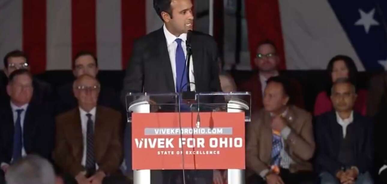 Vivek Ramaswamy speaking at a podium with a "Vivek for Ohio" sign during a 2026 gubernatorial campaign event.