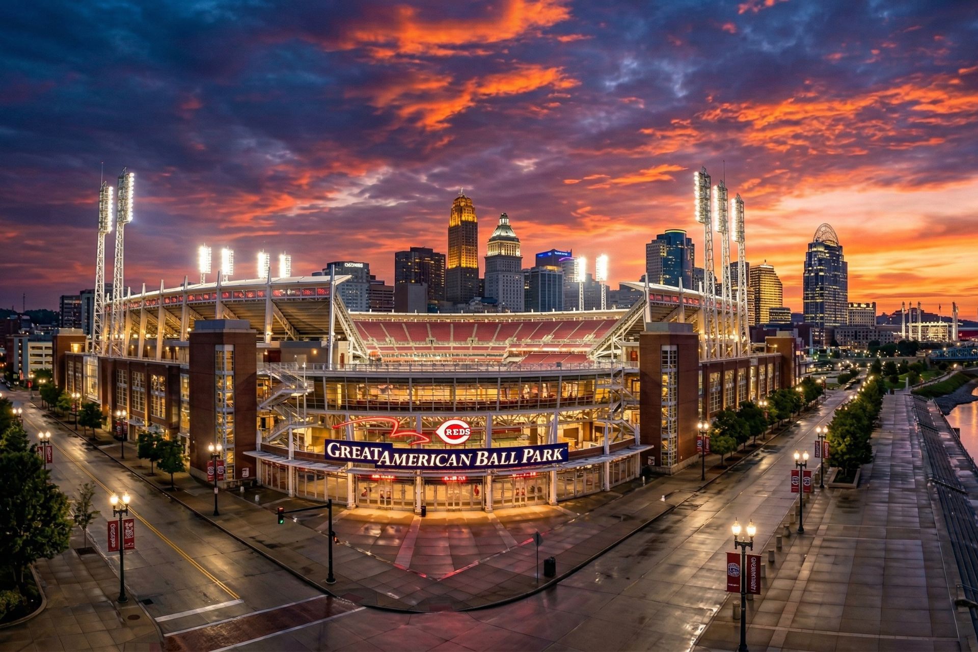 A wide-angle, cinematic view of the Great American Ball Park exterior in Cincinnati at sunset with the city skyline in the background.
