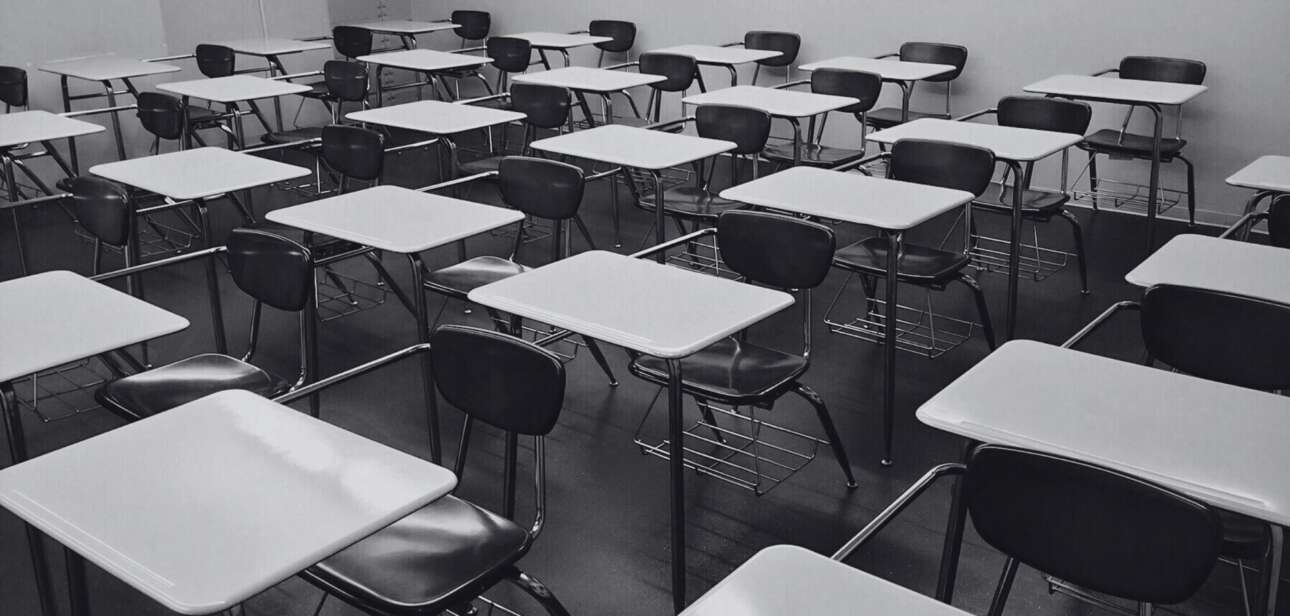 Empty classroom with rows of student desks, representing the evacuation of suburban schools in Indian Hill due to a bomb threat.