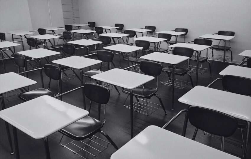 Empty classroom with rows of student desks, representing the evacuation of suburban schools in Indian Hill due to a bomb threat.