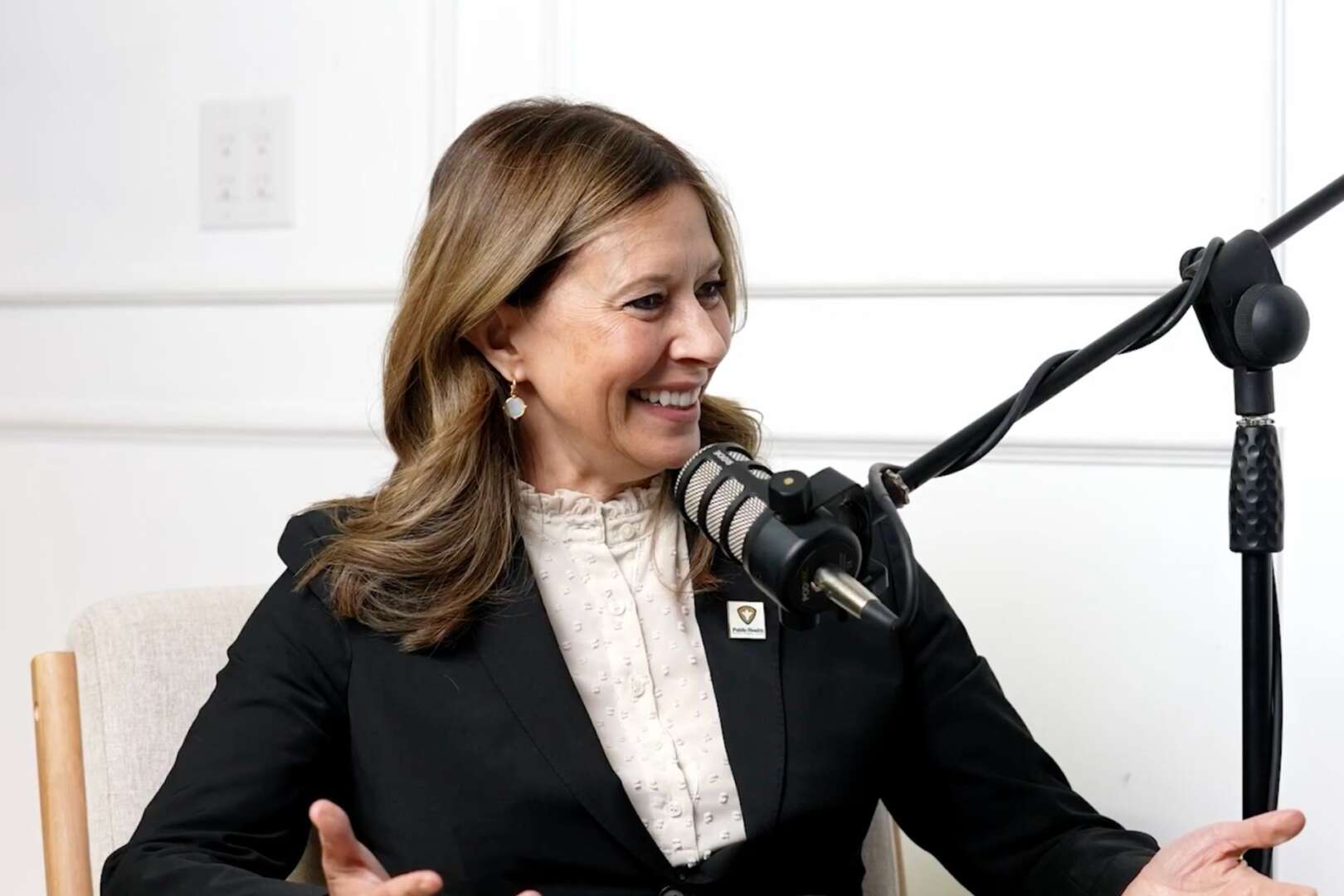Amy Acton speaking in front of a microphone for a sit down discussion.