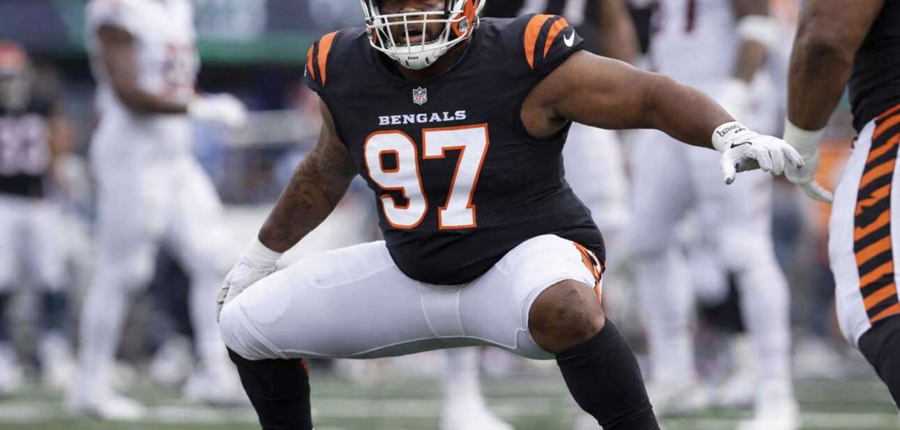 Cincinnati Bengals defensive lineman in orange uniform crouched at the line of scrimmage during an NFL game