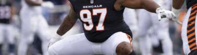 Cincinnati Bengals defensive lineman in orange uniform crouched at the line of scrimmage during an NFL game