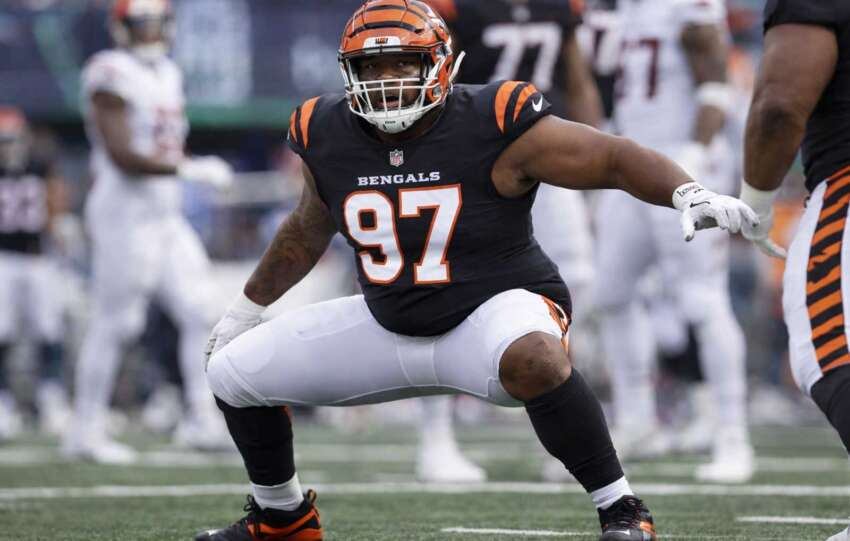 Cincinnati Bengals defensive lineman in orange uniform crouched at the line of scrimmage during an NFL game