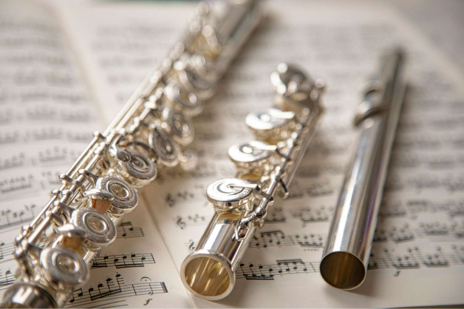 Disassembled silver flute on sheet music representing the Cincinnati court restitution case.