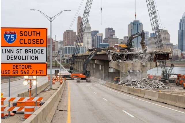 I-75 South interstate closure in Cincinnati for the Linn Street Bridge demolition, showing heavy construction equipment and detour signage.