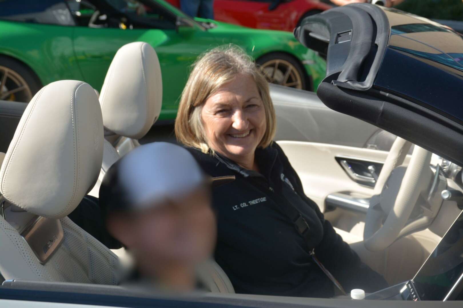 Cincinnati Police Chief Teresa Theetge smiling in a convertible car.