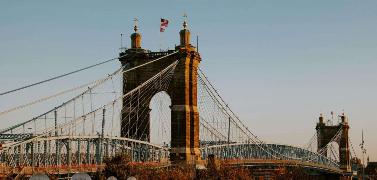 John A. Roebling Suspension Bridge in Cincinnati at sunset, symbolizing infrastructure and railway spending shifts in Ohio.