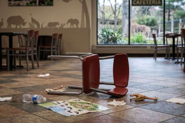 An overturned red chair and scattered debris on the floor of the Cincinnati Zoo cafeteria following a physical altercation.