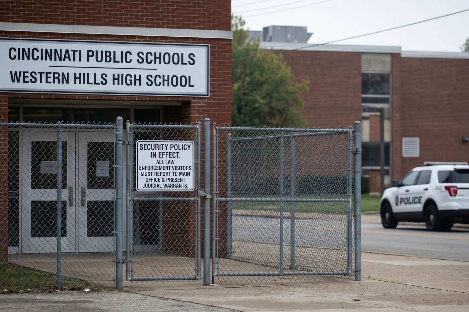 Western Hills High School entrance in Cincinnati featuring a security sign requiring law enforcement to present judicial warrants, following unauthorized ICE-related school visits.