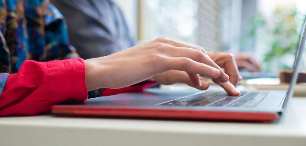 Student hands typing on a laptop, utilizing the new private AI tool at the University of Cincinnati.