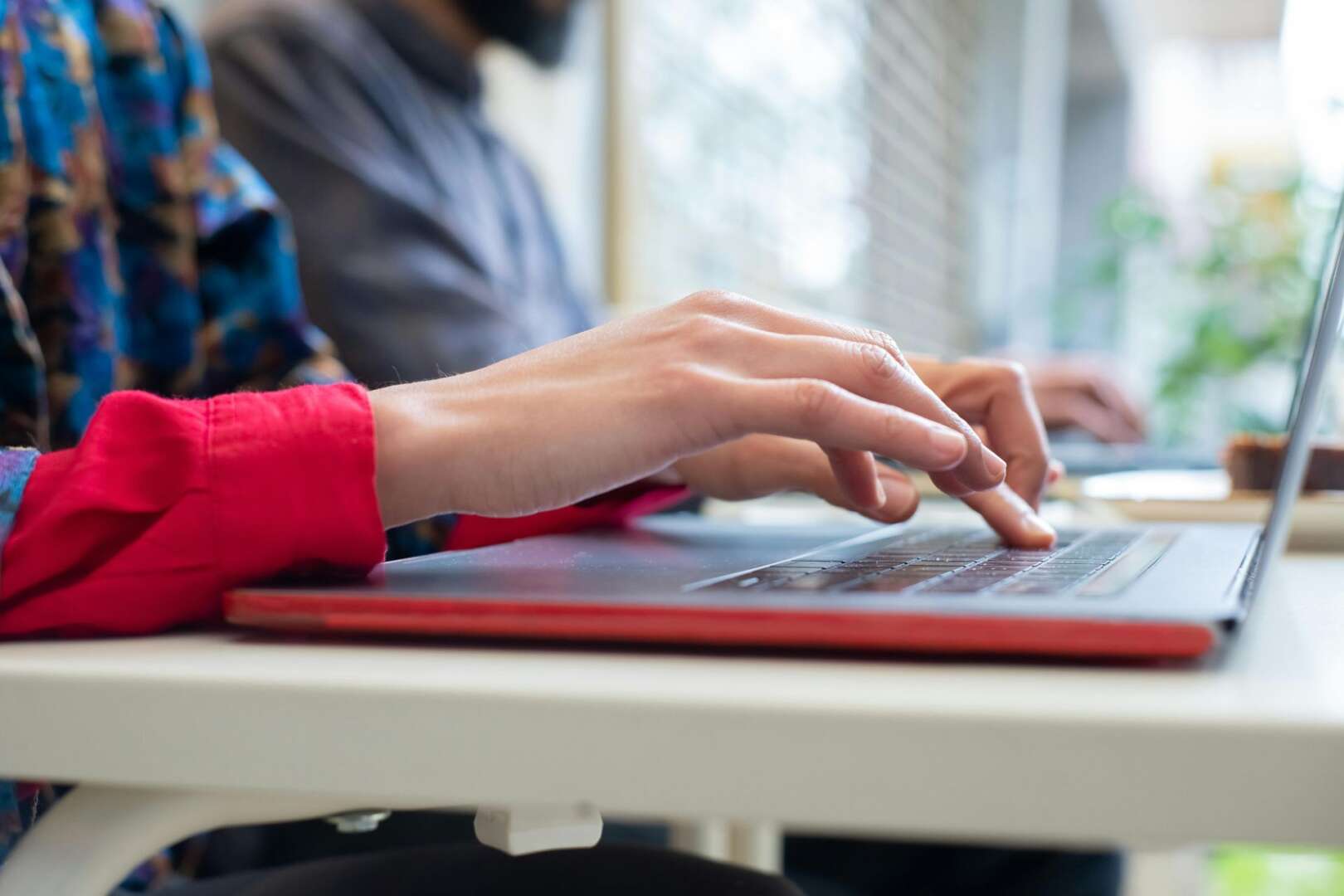 Student hands typing on a laptop, utilizing the new private AI tool at the University of Cincinnati.