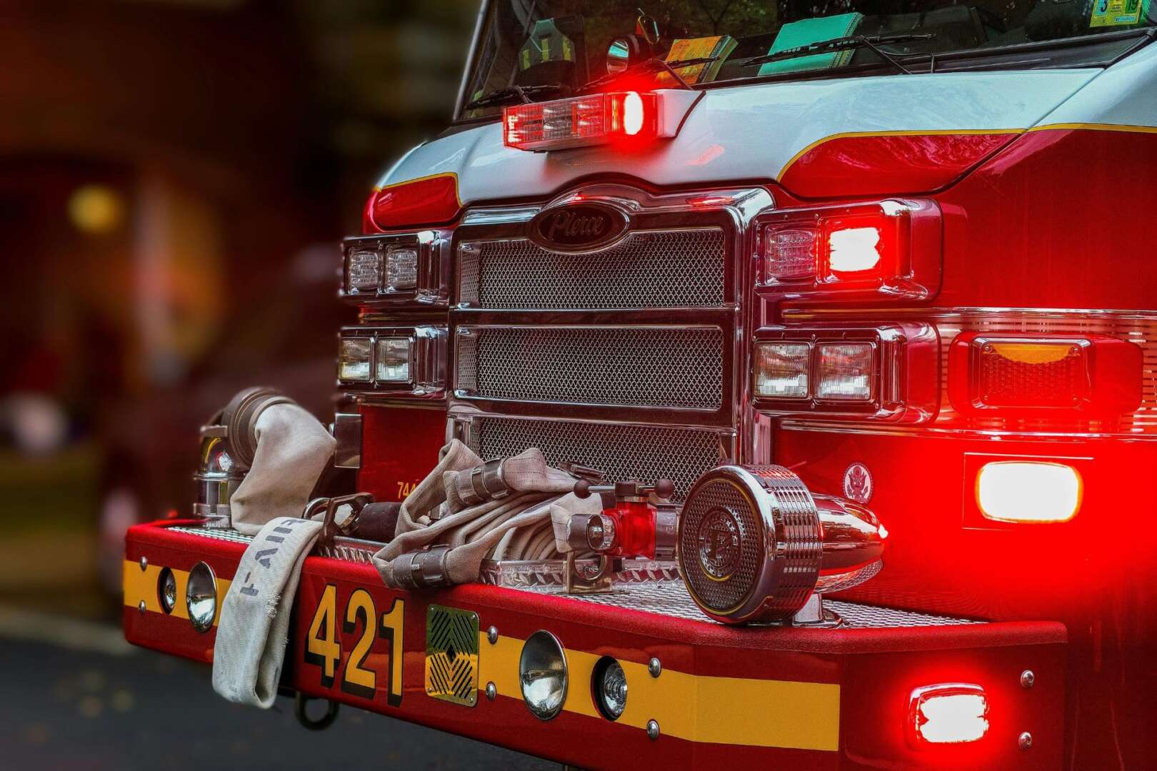 A detailed view of a fire truck bumper with hoses and equipment, showcasing emergency vehicle features.