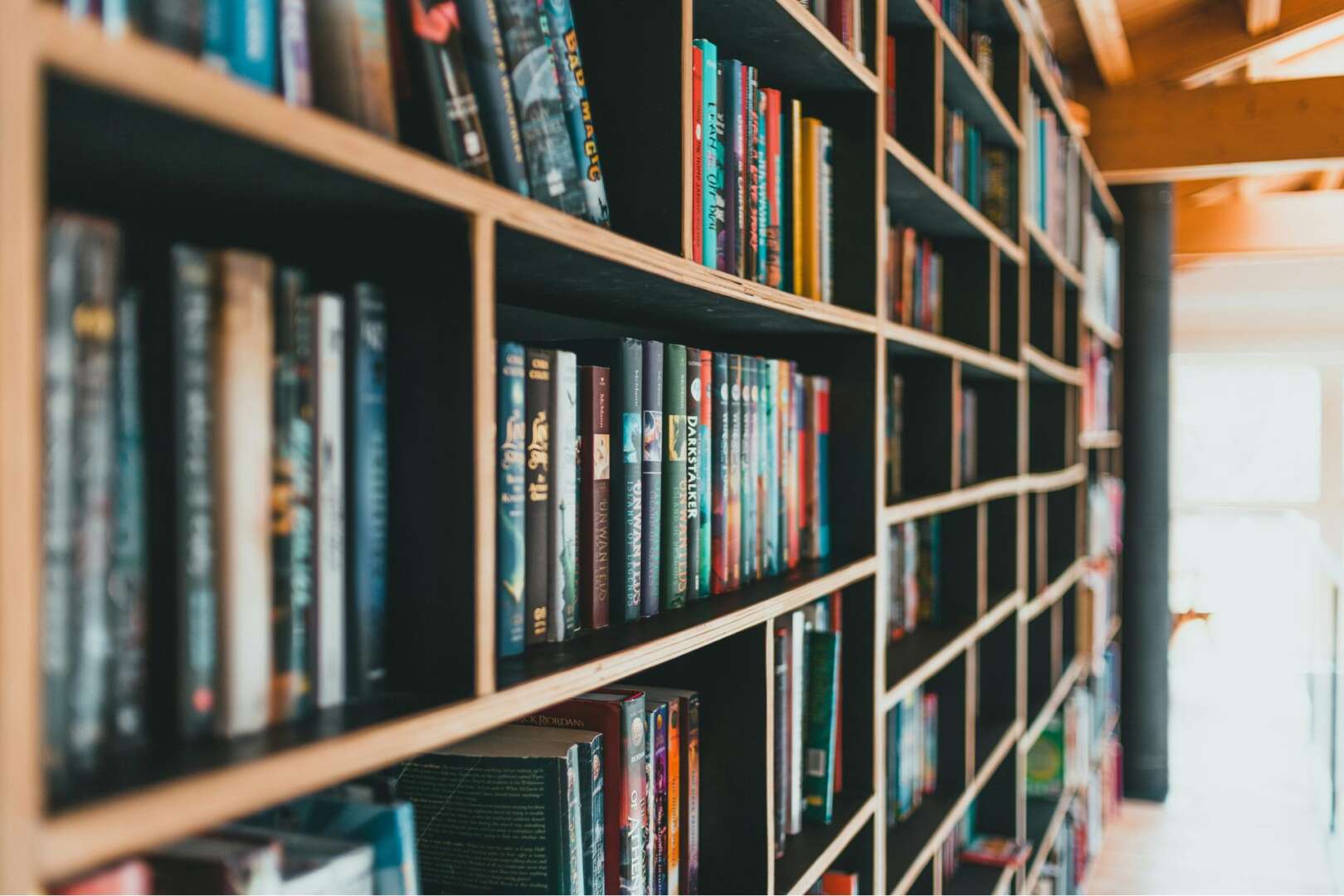 A wooden bookshelf tightly packed with various books, representing Cincinnati Public Library usage and physical reading habits.