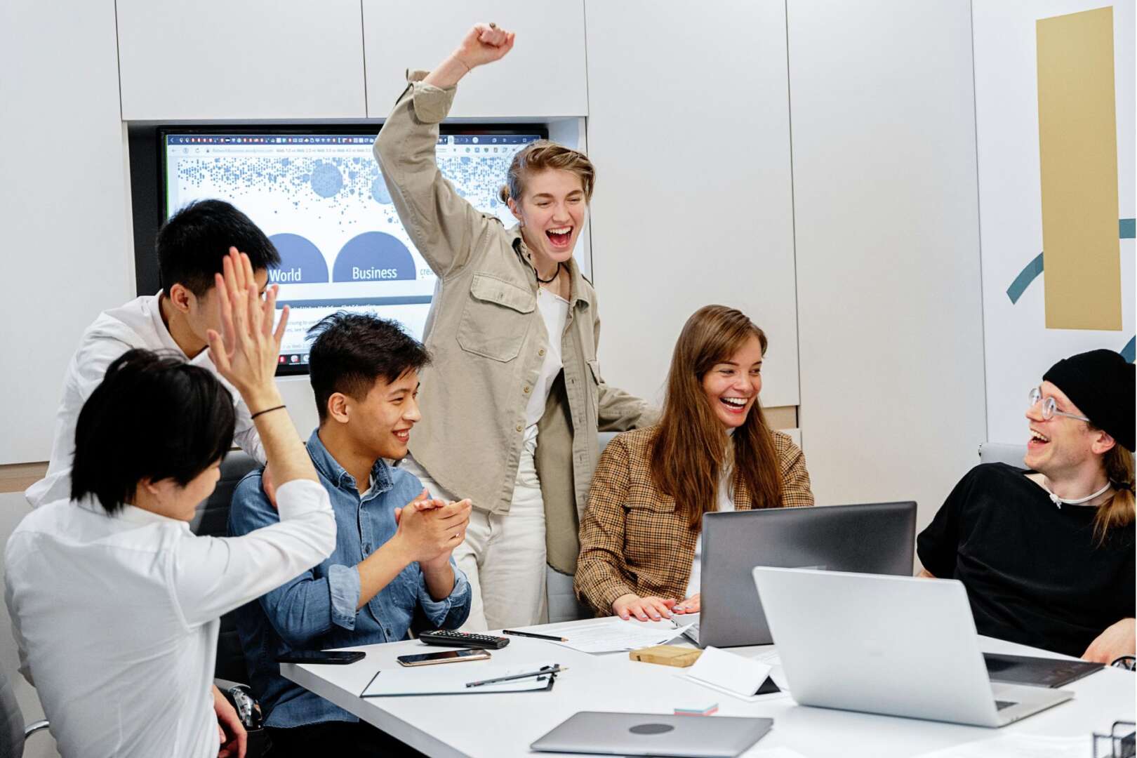 A diverse team of business professionals celebrating a milestone in a modern conference room, illustrating positive Cincinnati startup funding trends in 2026.
