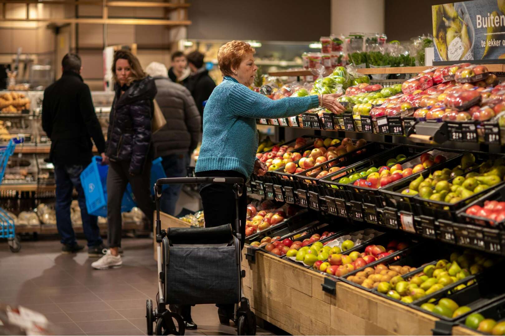 Customers shopping for fresh produce in a grocery store, reflecting current food supply chain dynamics and grocery prices in Cincinnati.