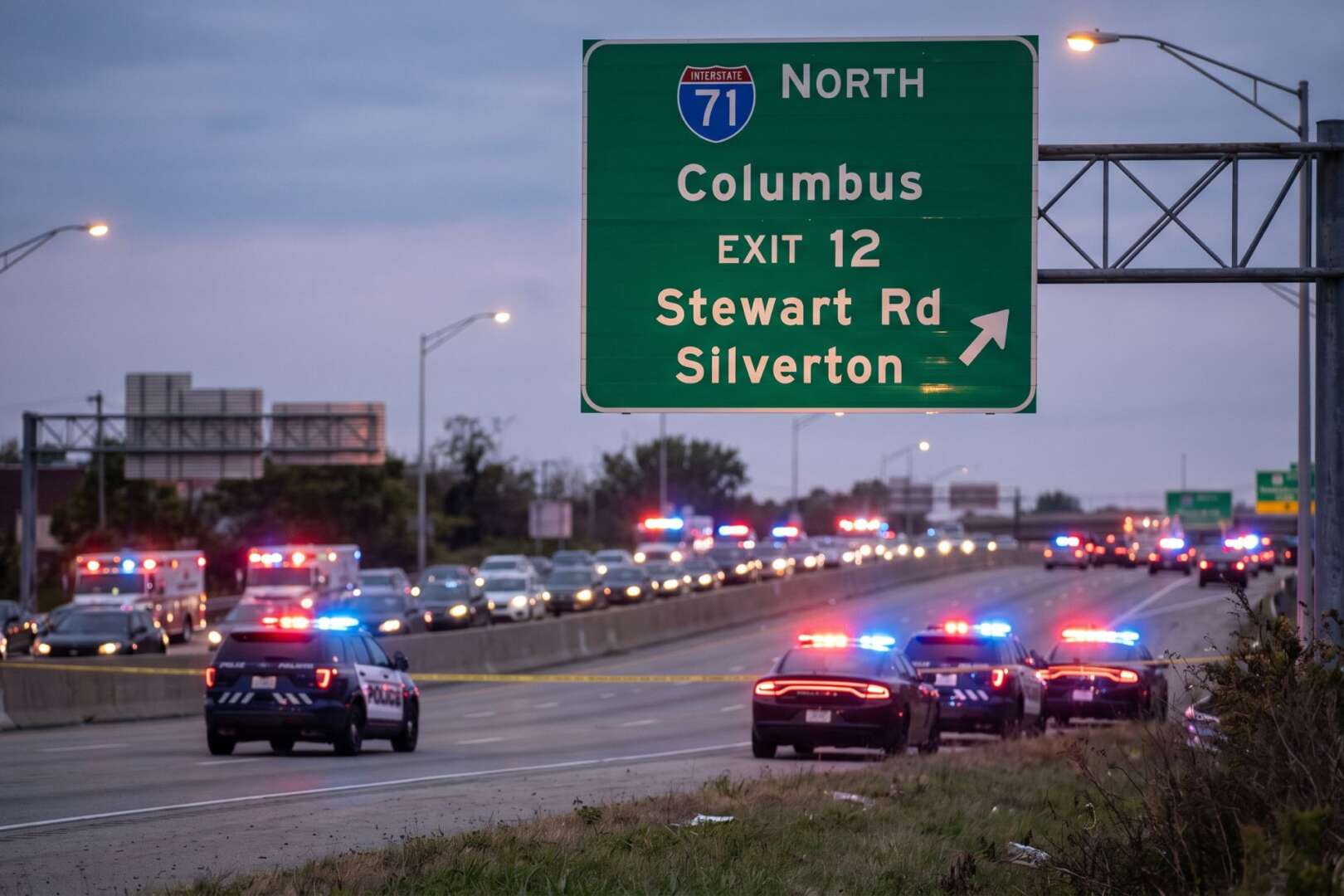 Multiple police cruisers with flashing emergency lights block traffic lanes on Interstate 71 North near the Stewart Road exit in Silverton during an investigation.