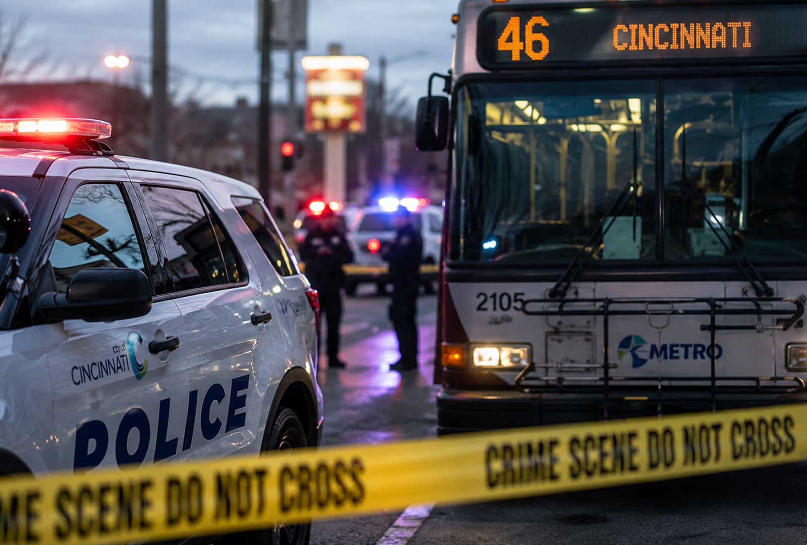 Cincinnati police vehicles and a Metro Route 46 bus at an active crime scene during a violent weekend across Cincinnati