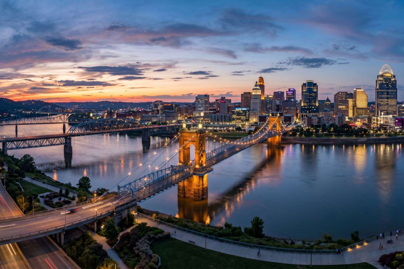 Aerial view of the Cincinnati skyline and the John A. Roebling Suspension Bridge at dusk.