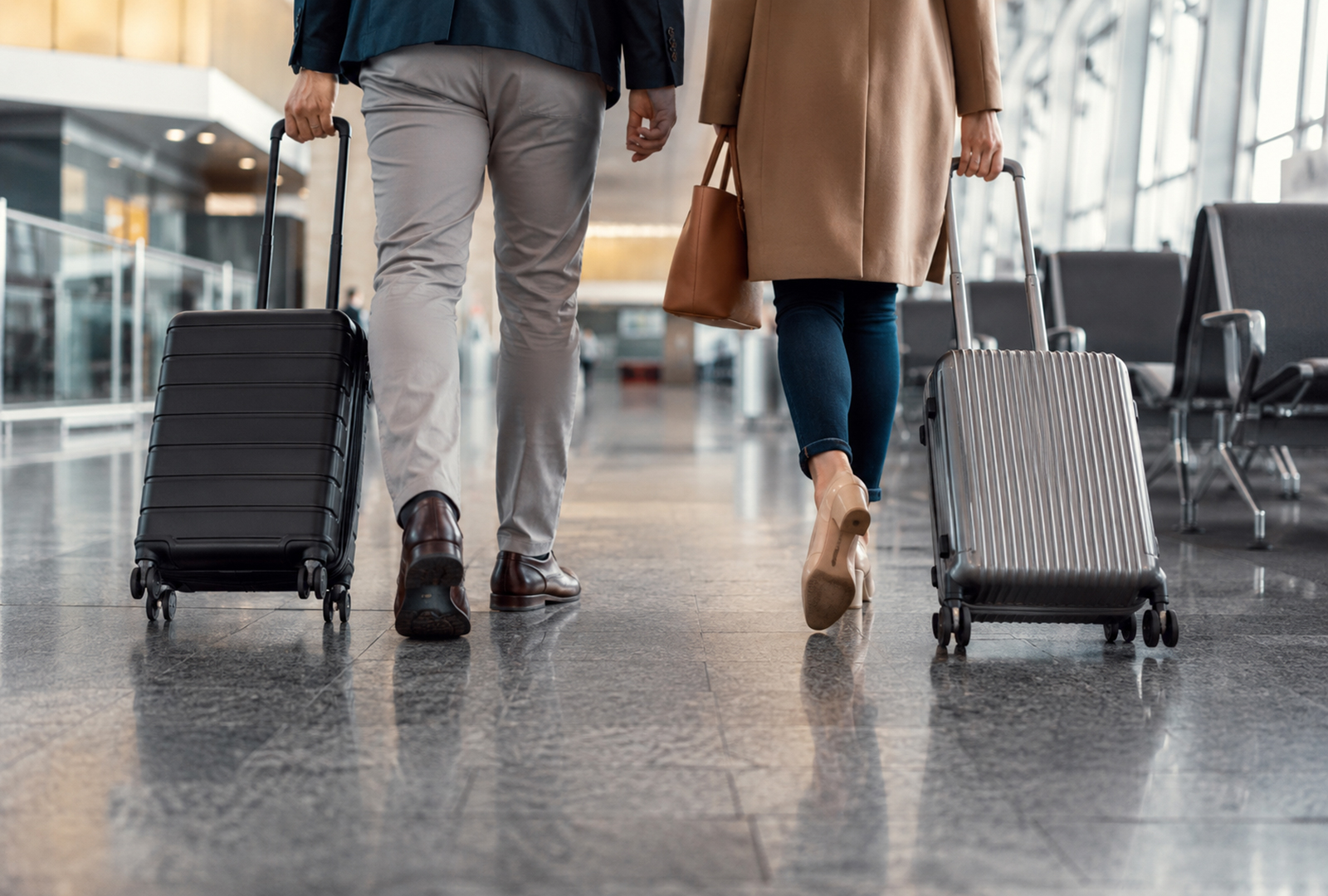 Travelers with rolling luggage at an airport represent Cincinnati domestic migration.