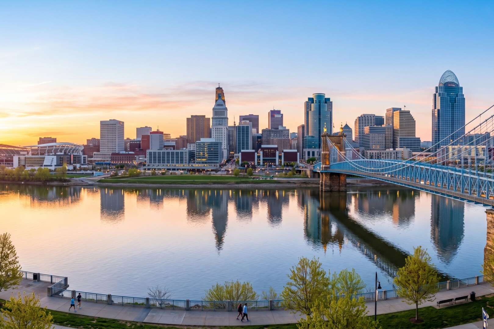 Cincinnati, Ohio downtown skyline reflecting on the river, representing local economic and job growth.
