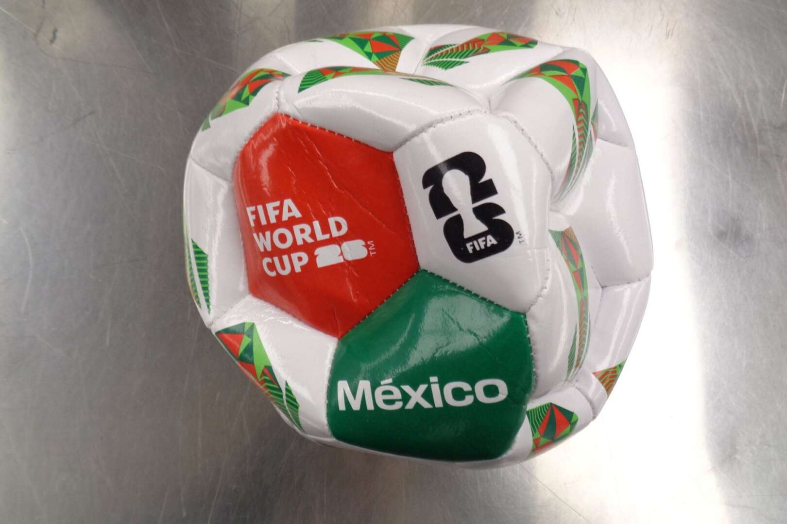 A counterfeit white, green, and red soccer ball with "FIFA World Cup" and "México" printed on it.