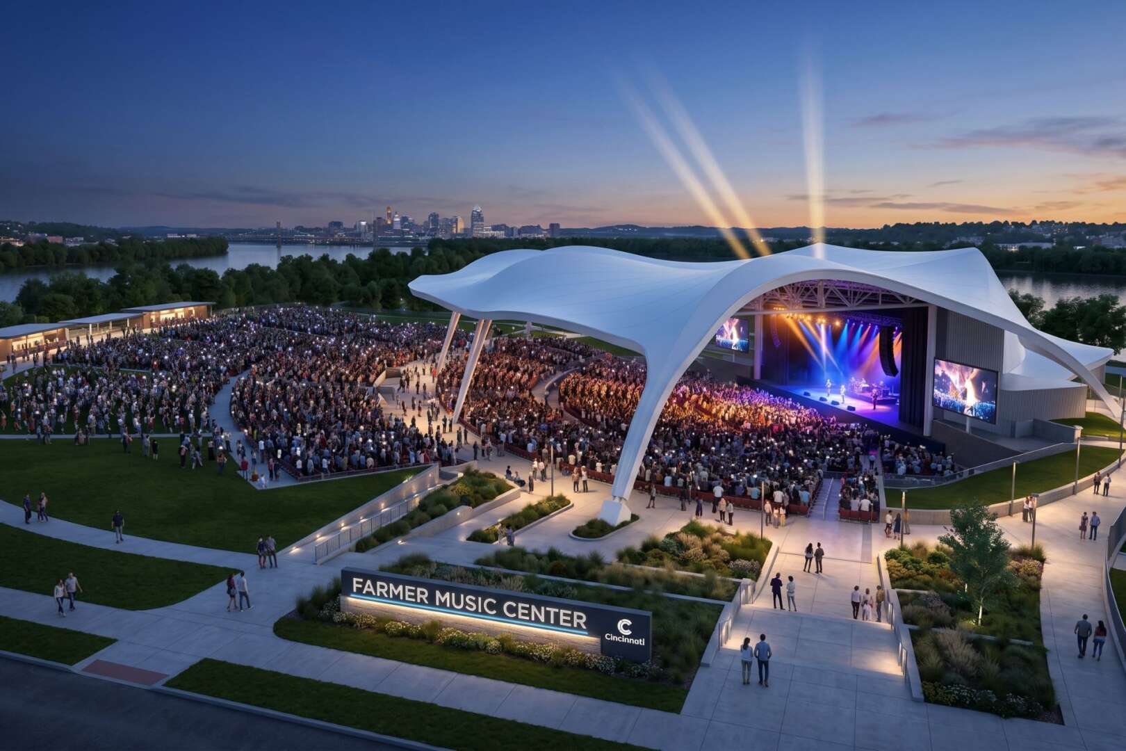 An outdoor amphitheater with a modern white canopy over the stage, filled with a large crowd at dusk.