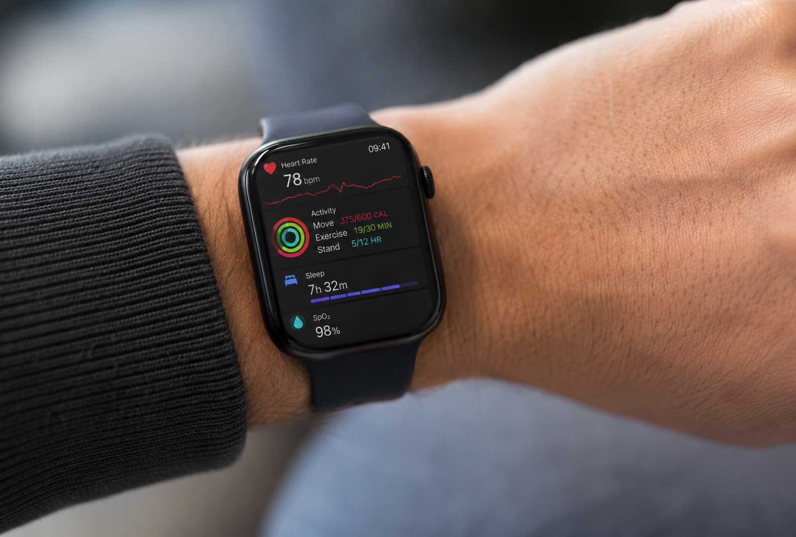 Fitness wearable displaying heart rate, activity, sleep and blood oxygen health metrics on a person’s wrist.