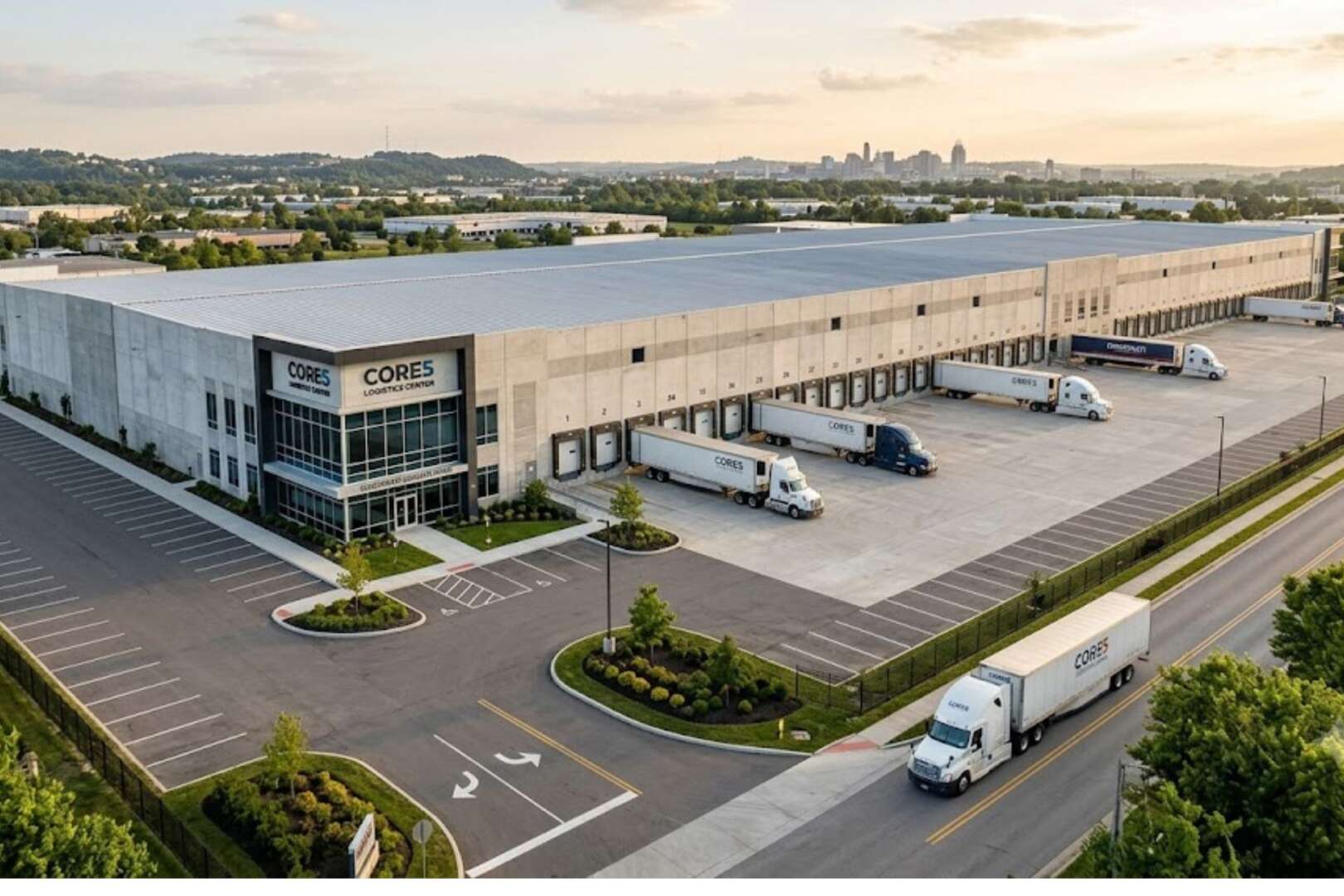 Aerial view of a modern industrial warehouse and distribution facility with multiple truck loading docks and parked semi-trucks.