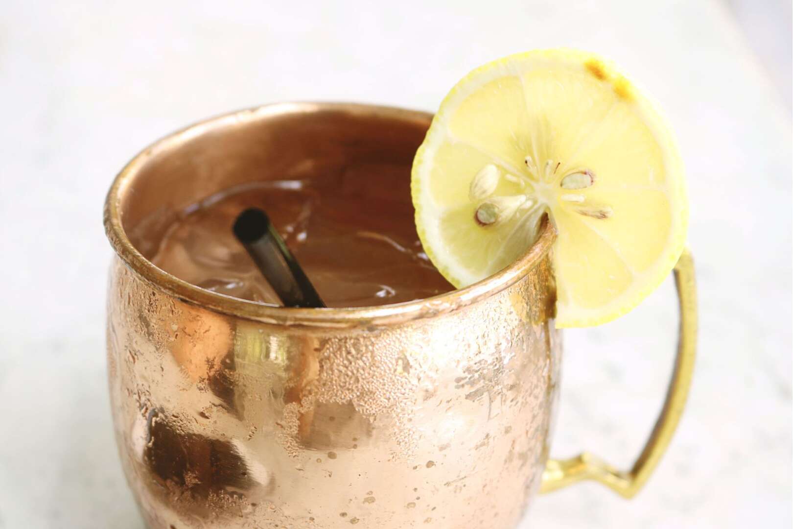 A refreshing iced drink in a copper mug with a lemon slice, symbolizing staying hydrated.