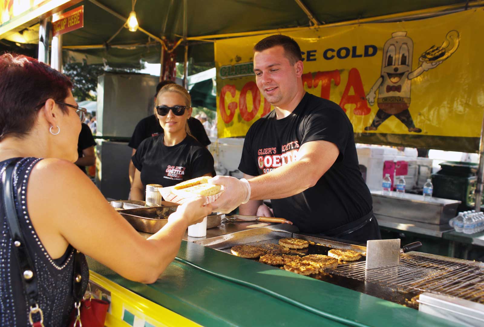 Goettafest vendors serve freshly grilled goetta to visitors at a busy food stand during Glier's Goettafest on the Newport riverfront.