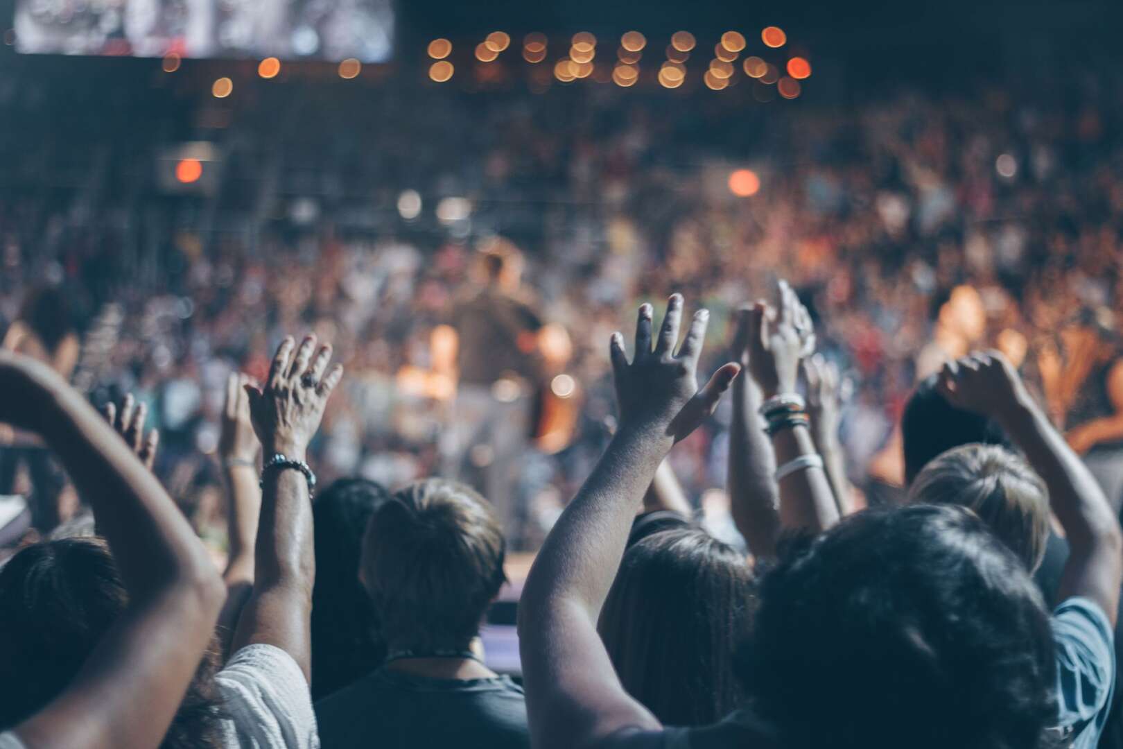 Concertgoers cheering with hands in the air at the Cincinnati Music Festival at Paycor Stadium.