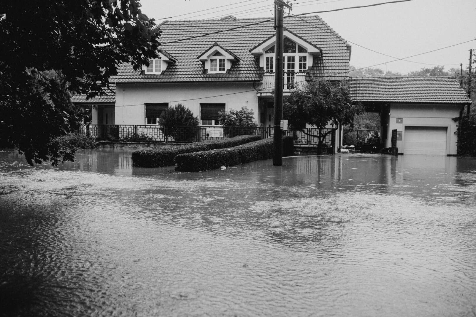 Deep floodwaters covering a residential street and surrounding homes in a Cincinnati neighborhood after severe flash flooding.