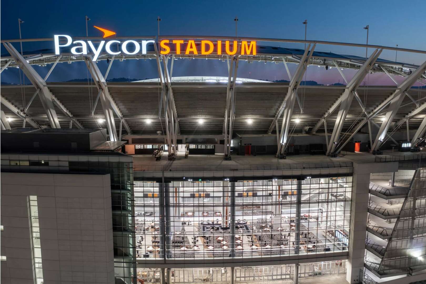 High-angle exterior view of Paycor Stadium with illuminated signage showcasing Phase 1 renovations.