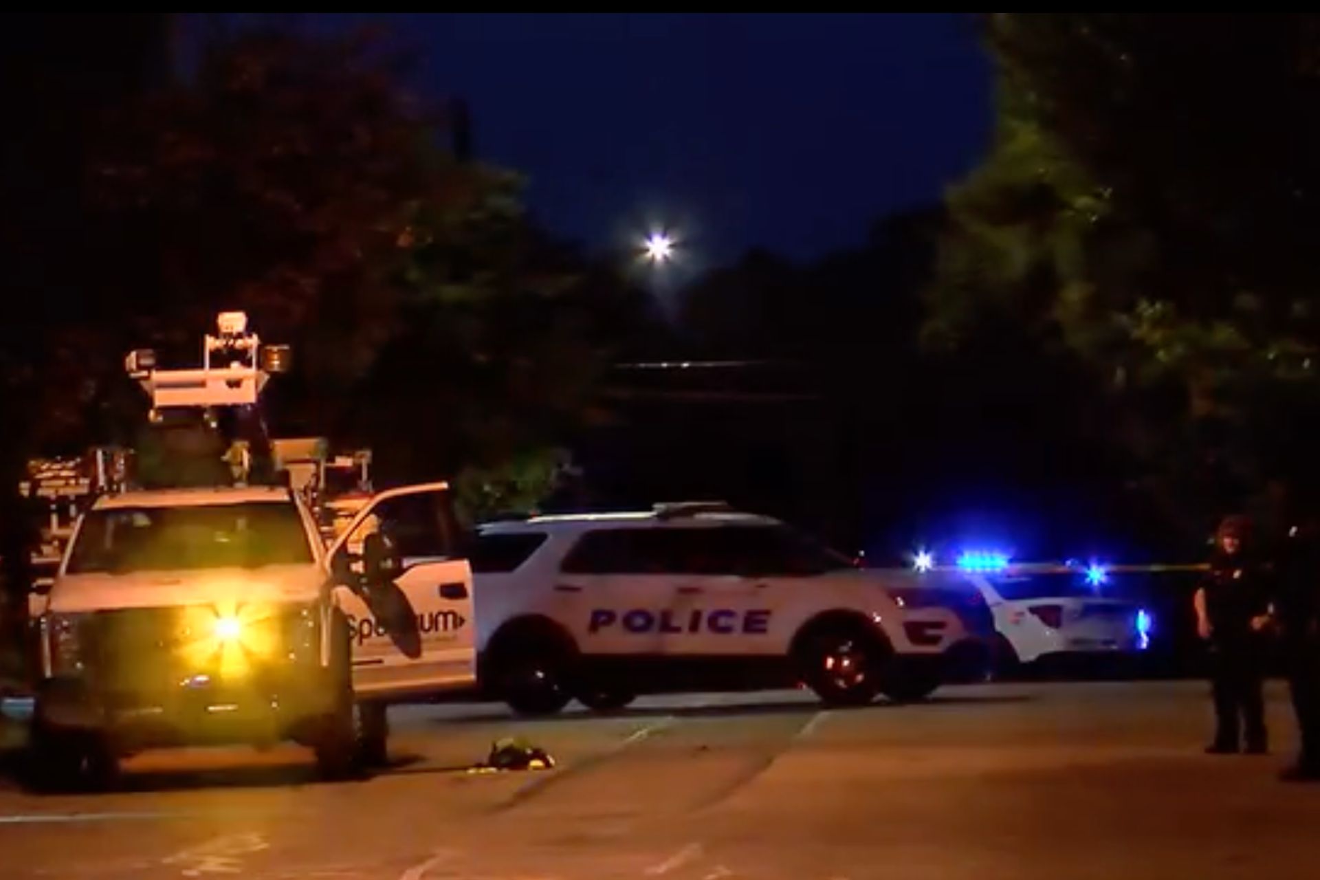 Police cars with flashing emergency lights parked at a night crime scene.