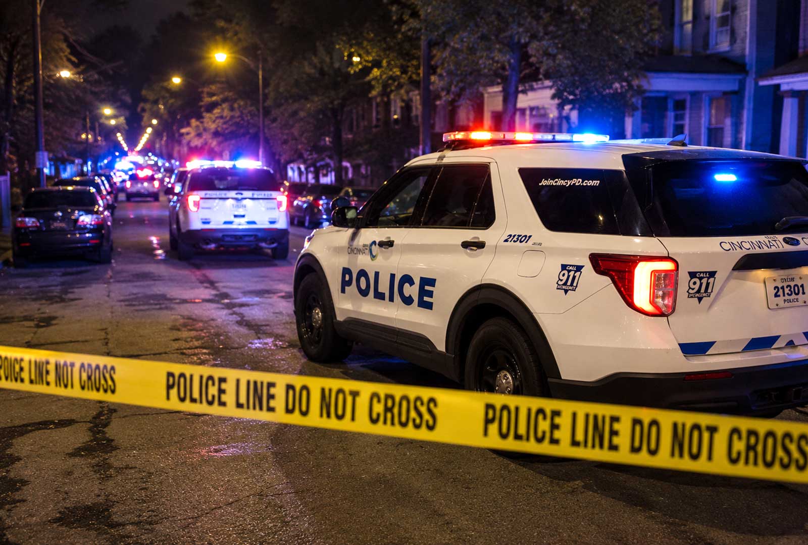 Winton Hills shooting in Cincinnati. Cincinnati Police SUVs with flashing emergency lights behind police tape during a nighttime crime scene, representing this week's Cincinnati crime roundup.