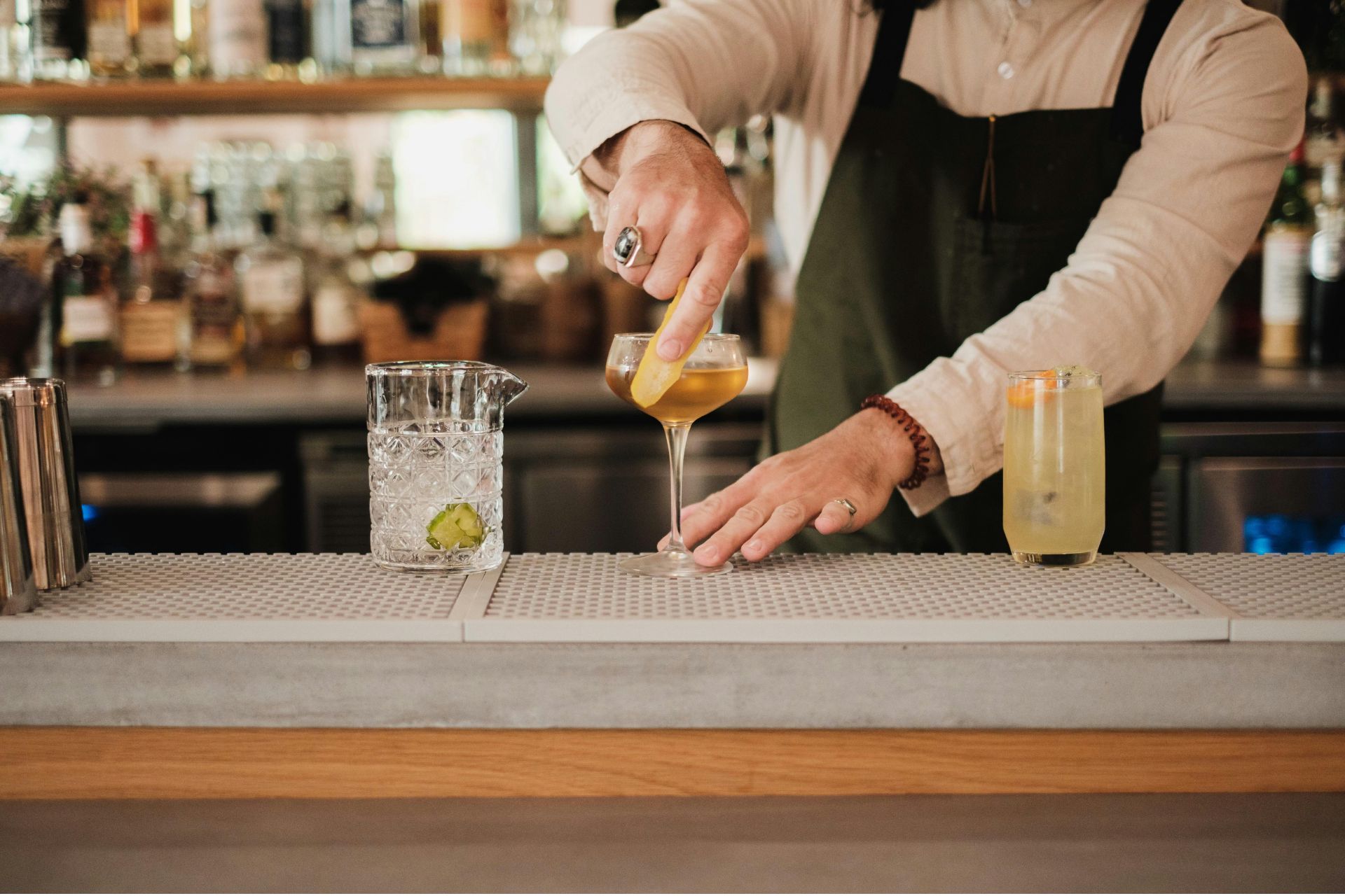 Bartender preparing a drink at a bar counter, illustrating Cincinnati nightlife and hospitality operations.