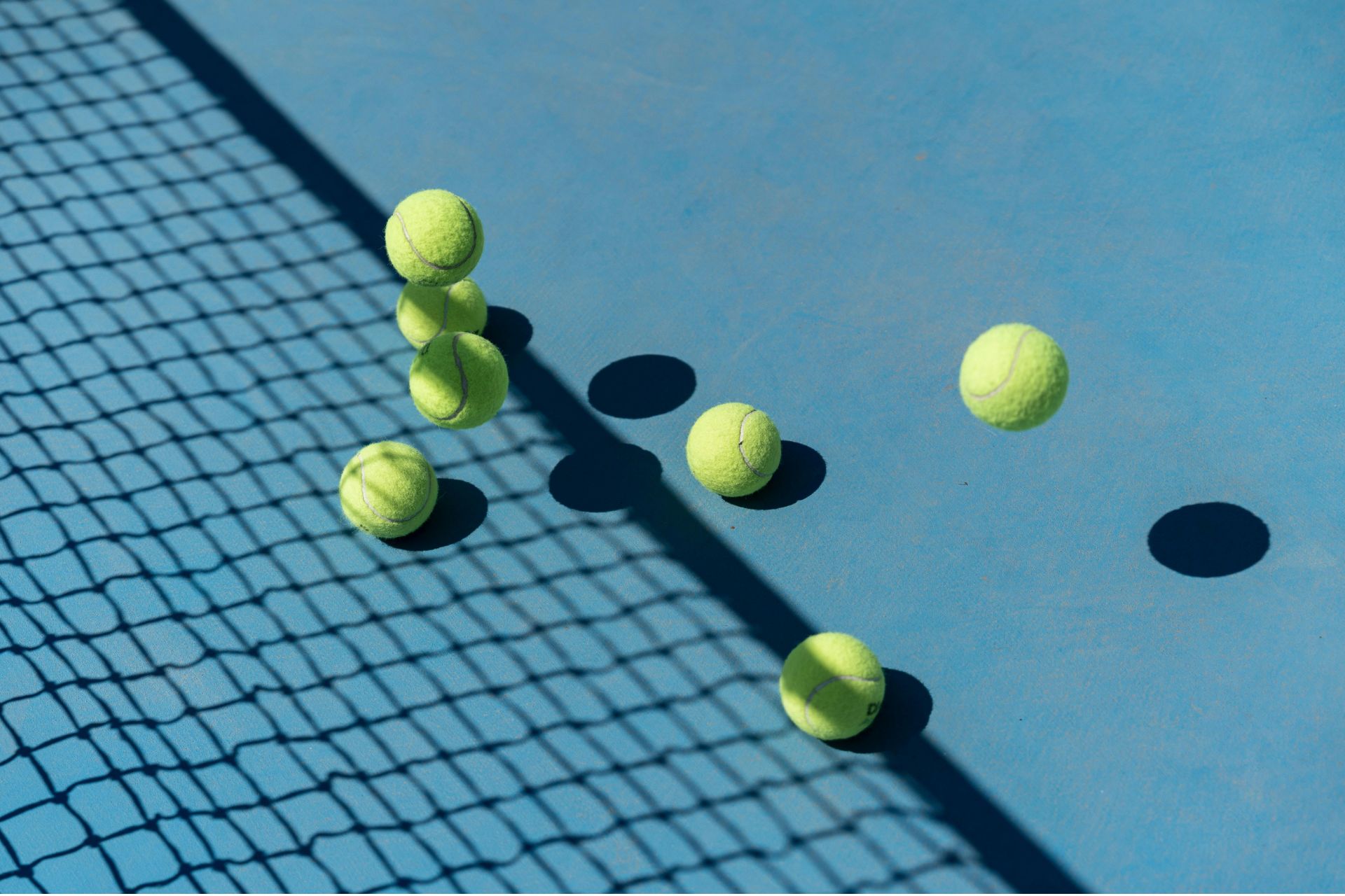 Blue tennis court surface and net with tennis balls representing the 2026 Cincinnati Open champions.
