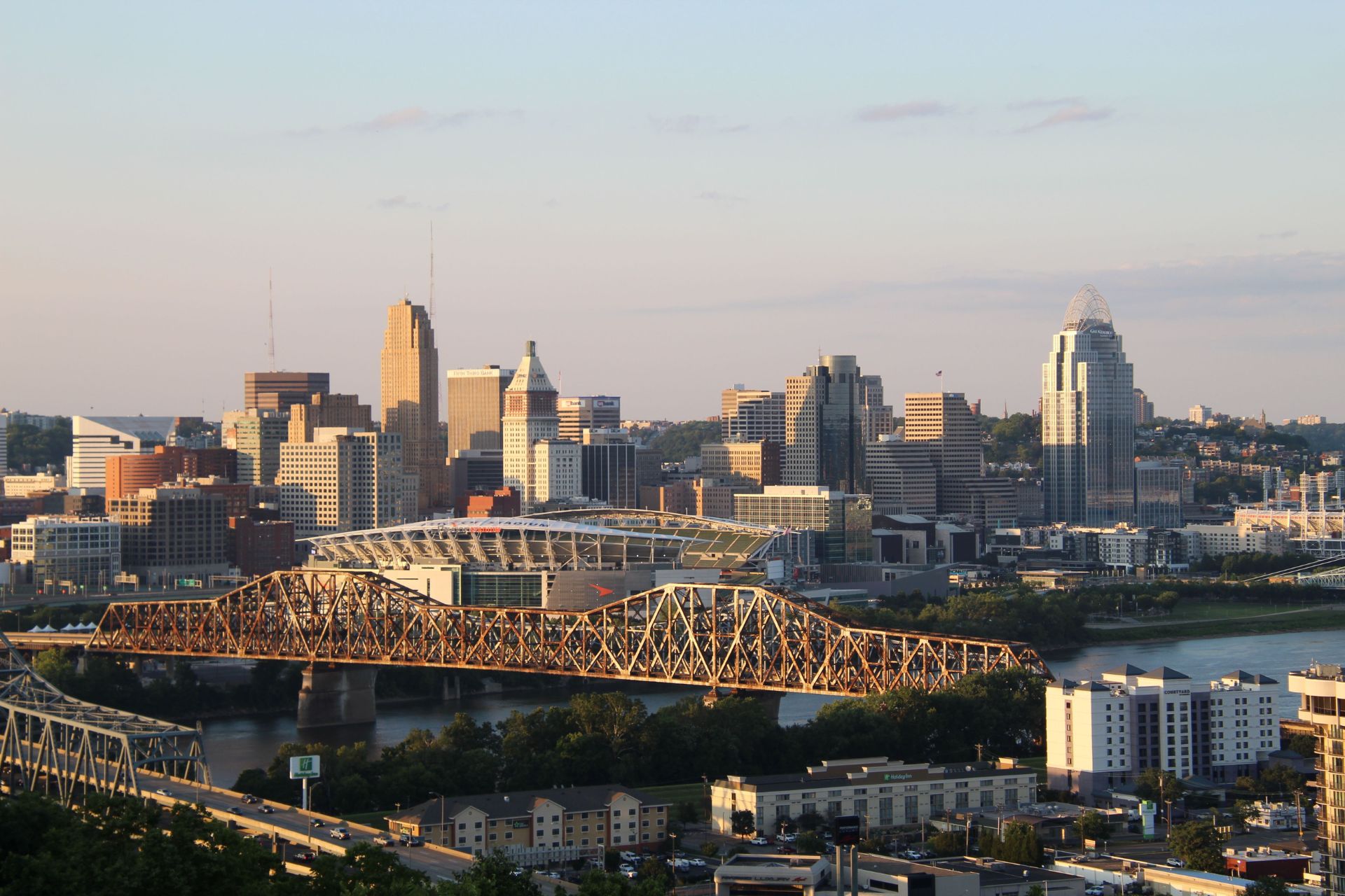 Panoramic view of the Cincinnati skyline and Ohio River bridges in Hamilton County at sunset.