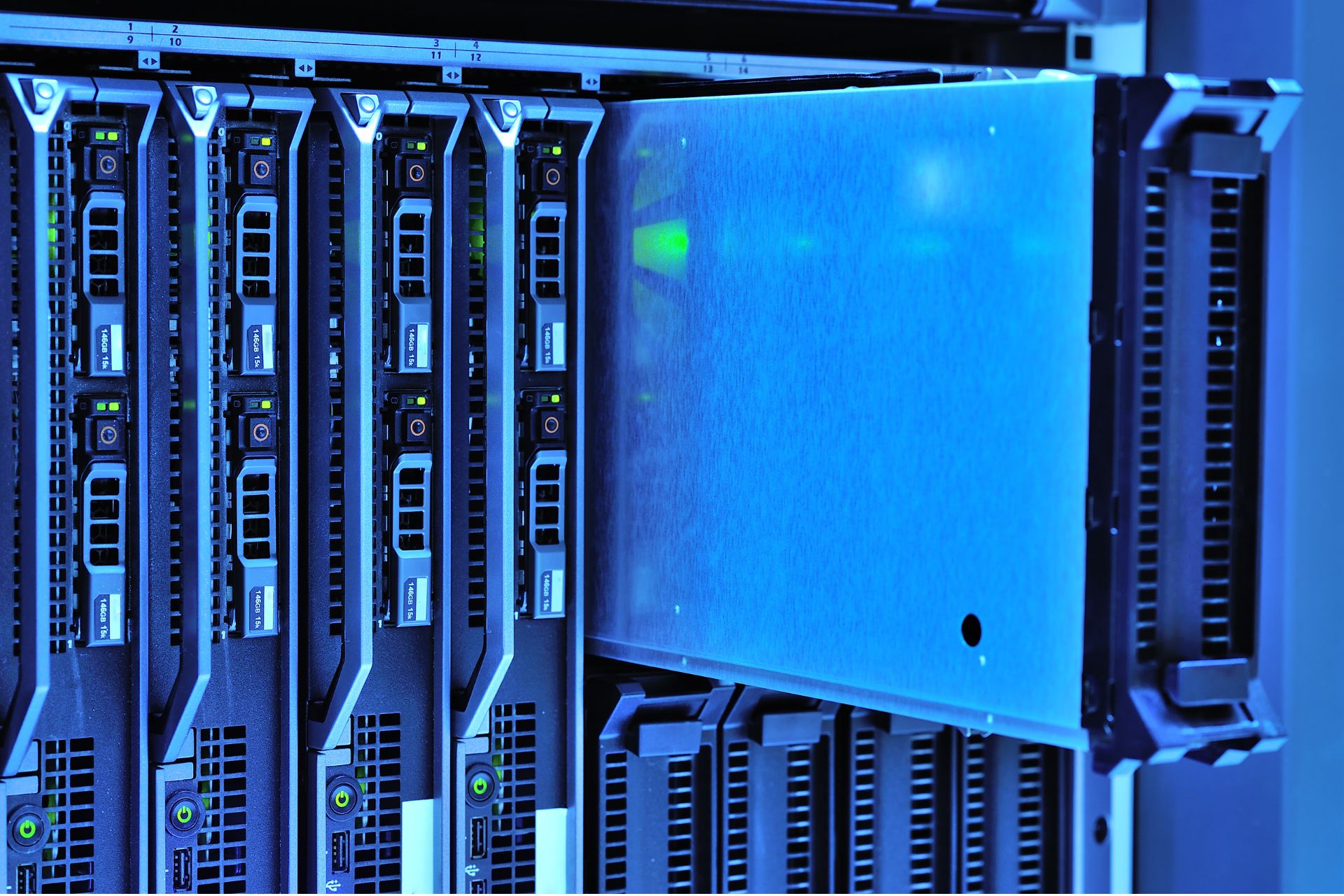 Server racks with glowing blue lights inside a modern data center facility.