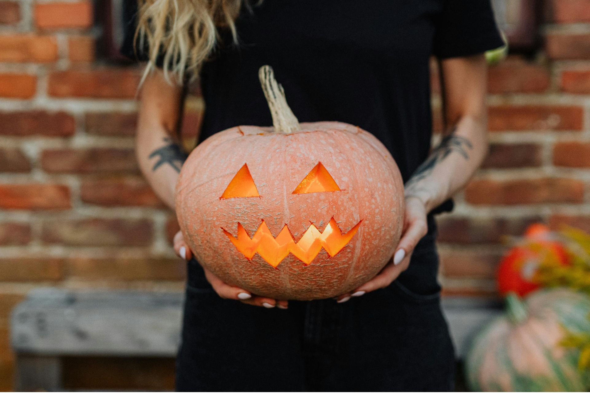 Person holding a glowing carved jack-o'-lantern at the Cincinnati Zoo Jack O' Lantern Glow