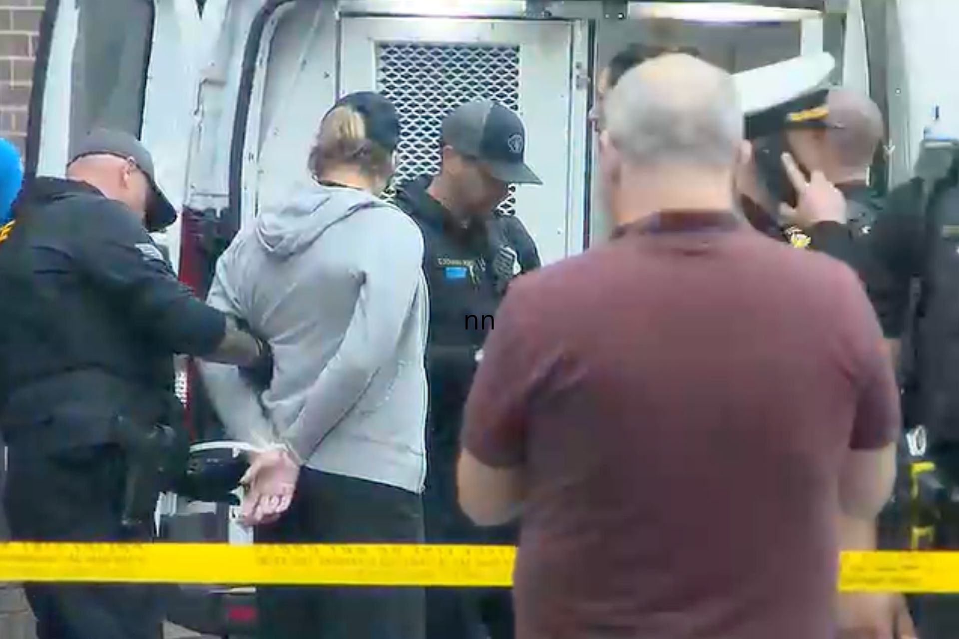 Police officers handcuffing a demonstrator during a Kroger protest in Cincinnati.