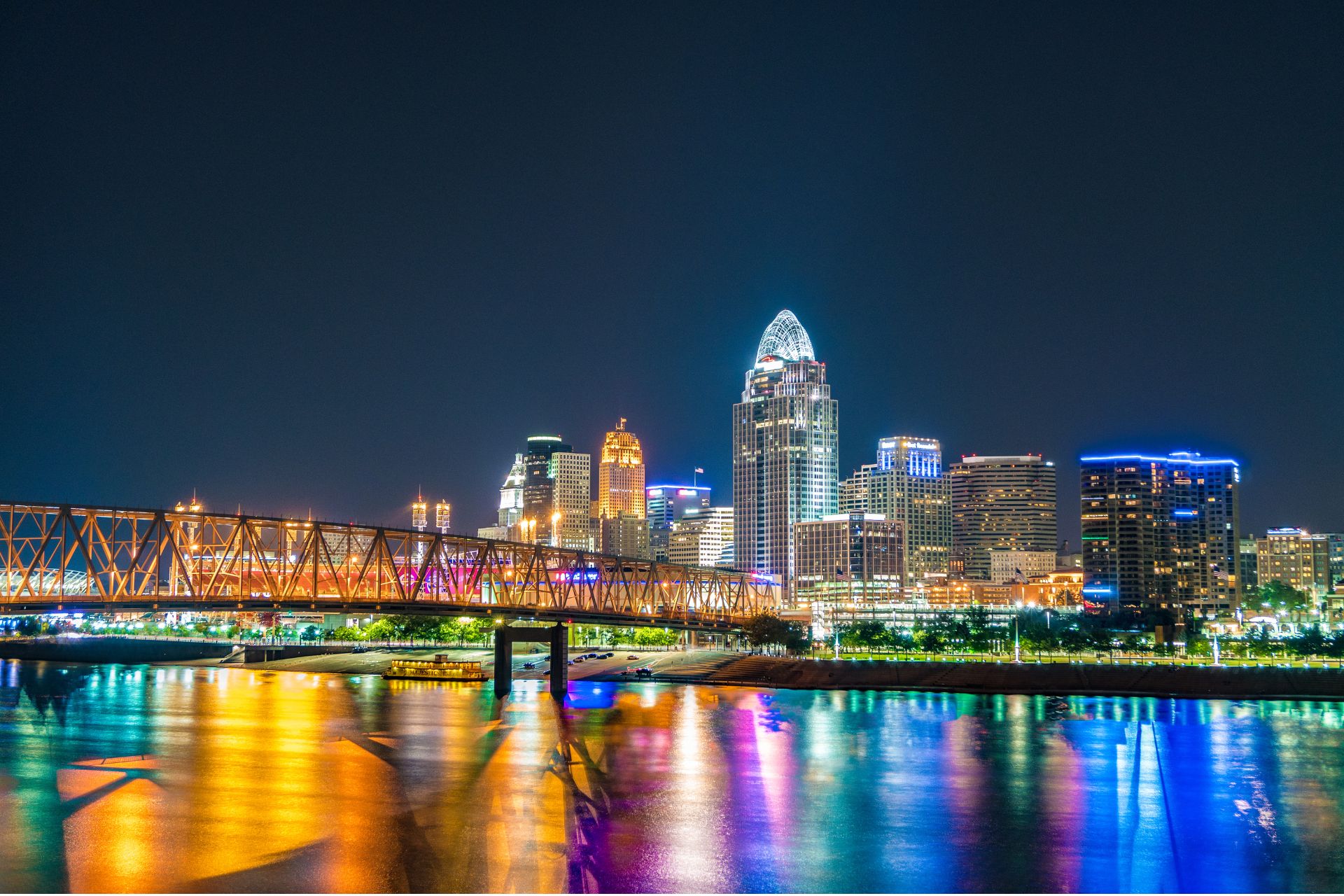 The Cincinnati Exchange news graphic: “OSHA investigates fatal crane accident at Brent Spence bridge project,” over a silhouette of a construction worker in a hard hat and safety vest against an orange sunset