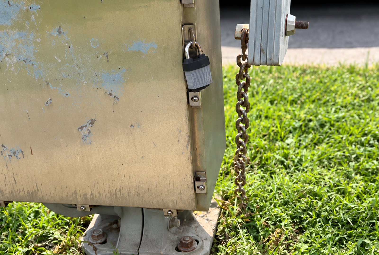Chain attached to a crossing-arm assembly at Cincinnati's Madison Road floodgate over Duck Creek railroad arms in July 2026.